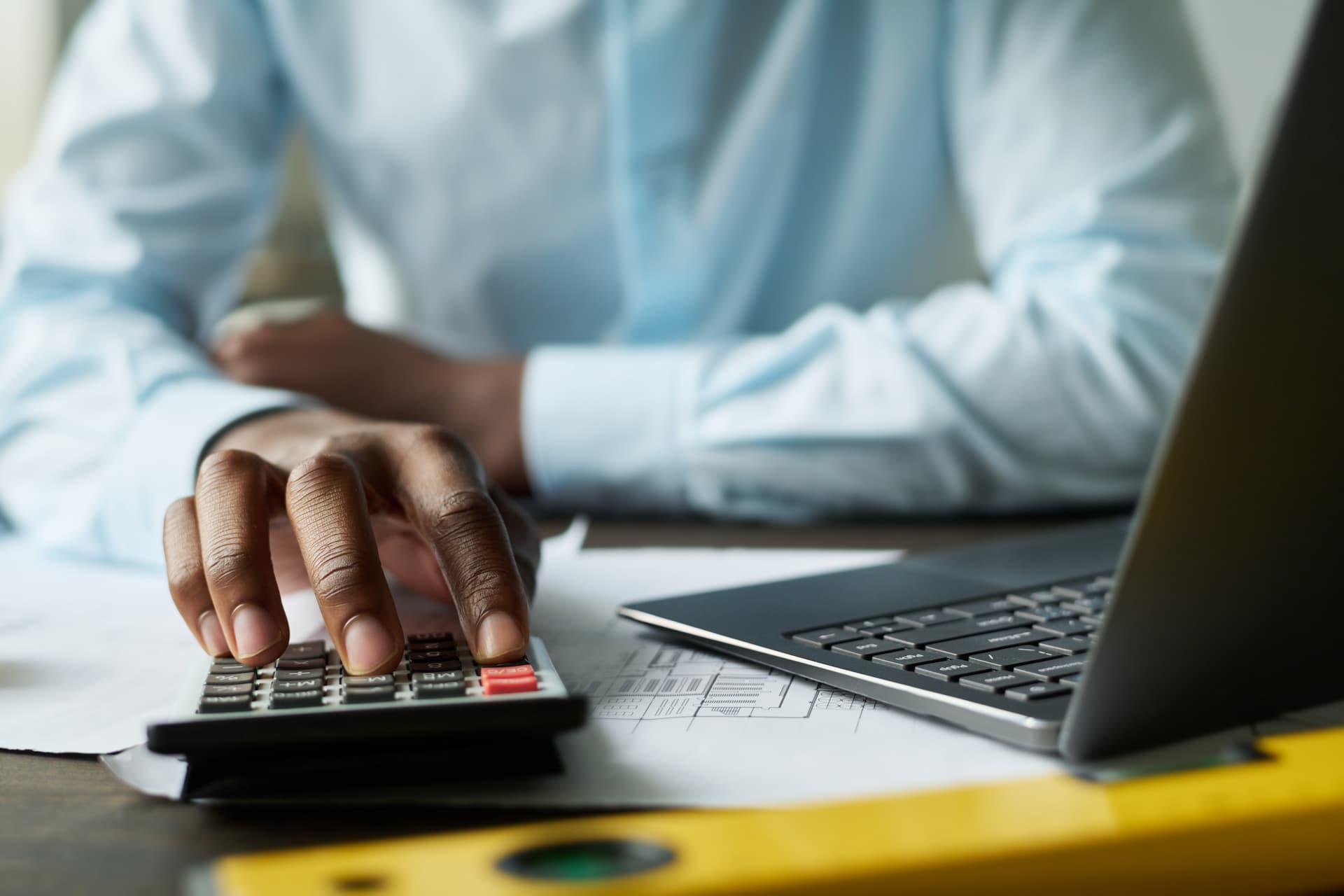hand of male accountant using calculator